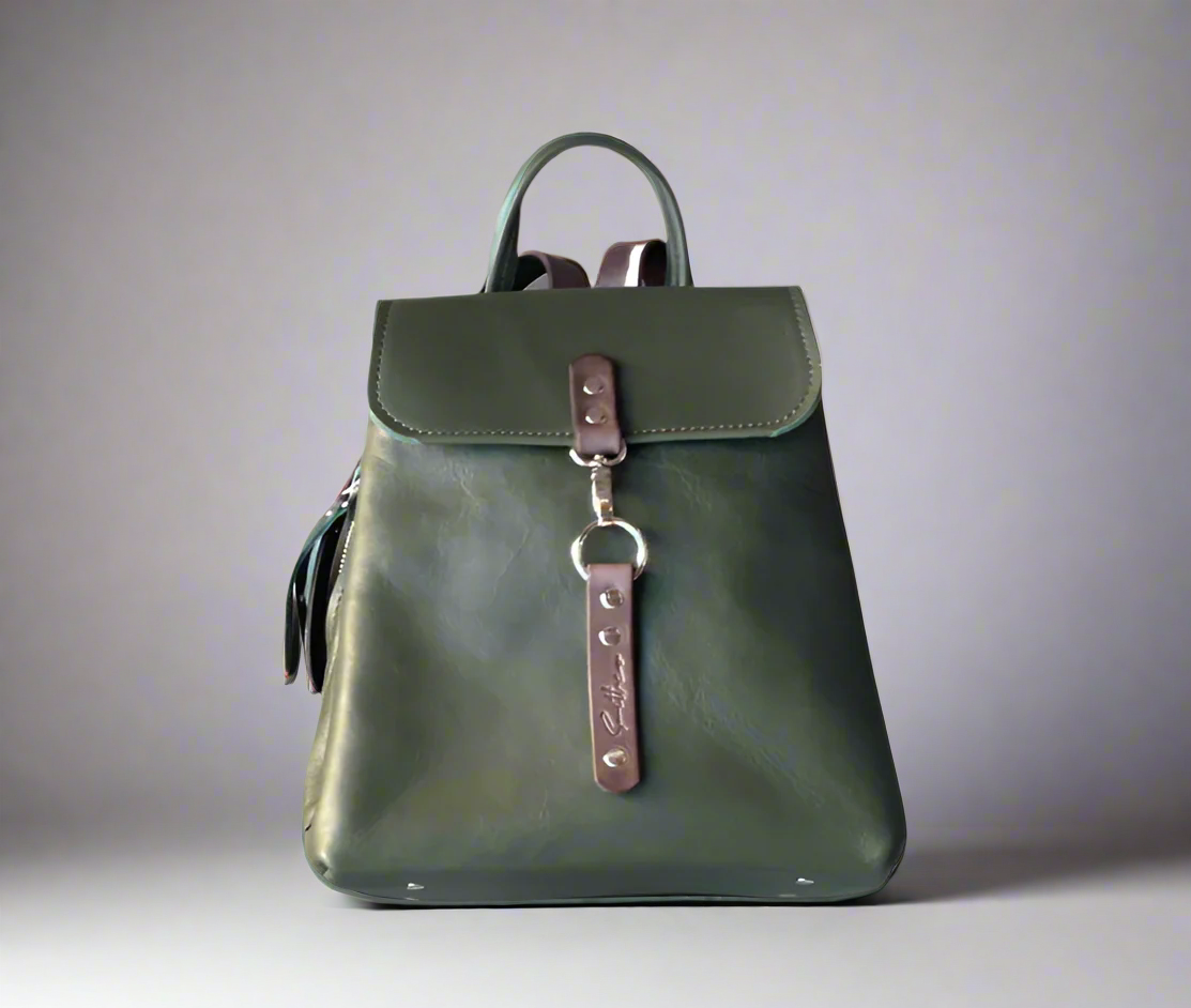 Compact full grain leather backpack in forest green with brown detail with sturdy veg tan shoulder straps and a secure outer easy access pocket. Handmade by women in Cape Town.