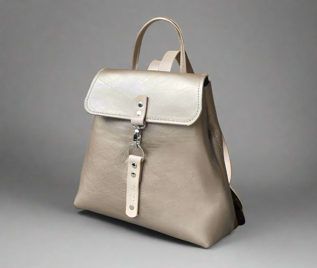 Compact full grain leather backpack in gold natural detail with sturdy veg tan shoulder straps and a secure outer easy access pocket. Handmade by women in Cape Town.
