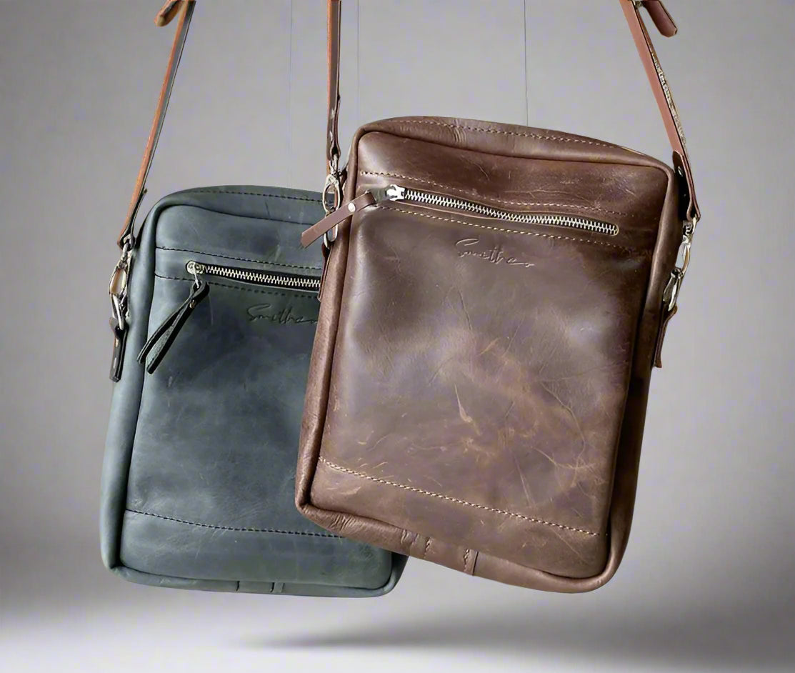 Full grain leather crossbody sling bag in distressed brown and denim blue, featuring an two exterior zipped pockets and adjustable strap. Handmade in Cape Town