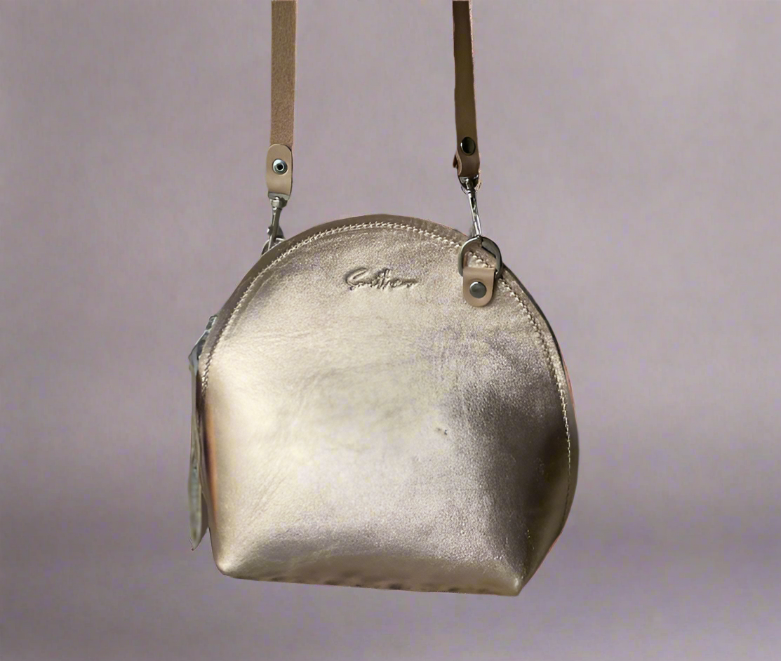 The Arc mini crossbody leather bag in metallic pink