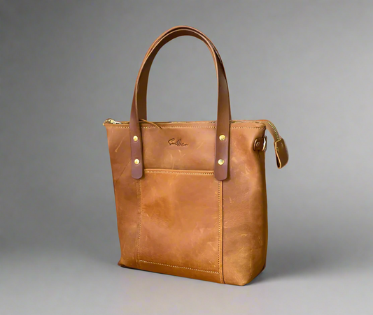 Toffee coloured mini tote bag in full grain leather with gold fittings and a crossbody strap