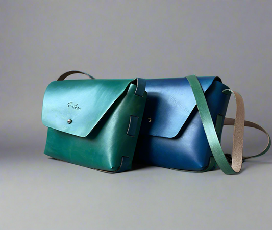 Smooth full grain hand-dyed leather crossbody bag with raw edges and no stitching, handmade in Cape Town. Available in bold vibrant colours - Blue and Turquoise - or natural tones