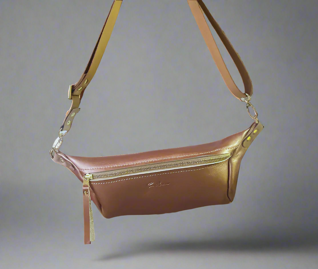 Rose gold full grain leather Moonsling crossbody bag with curved shape and adjustable strap, handmade in Cape Town