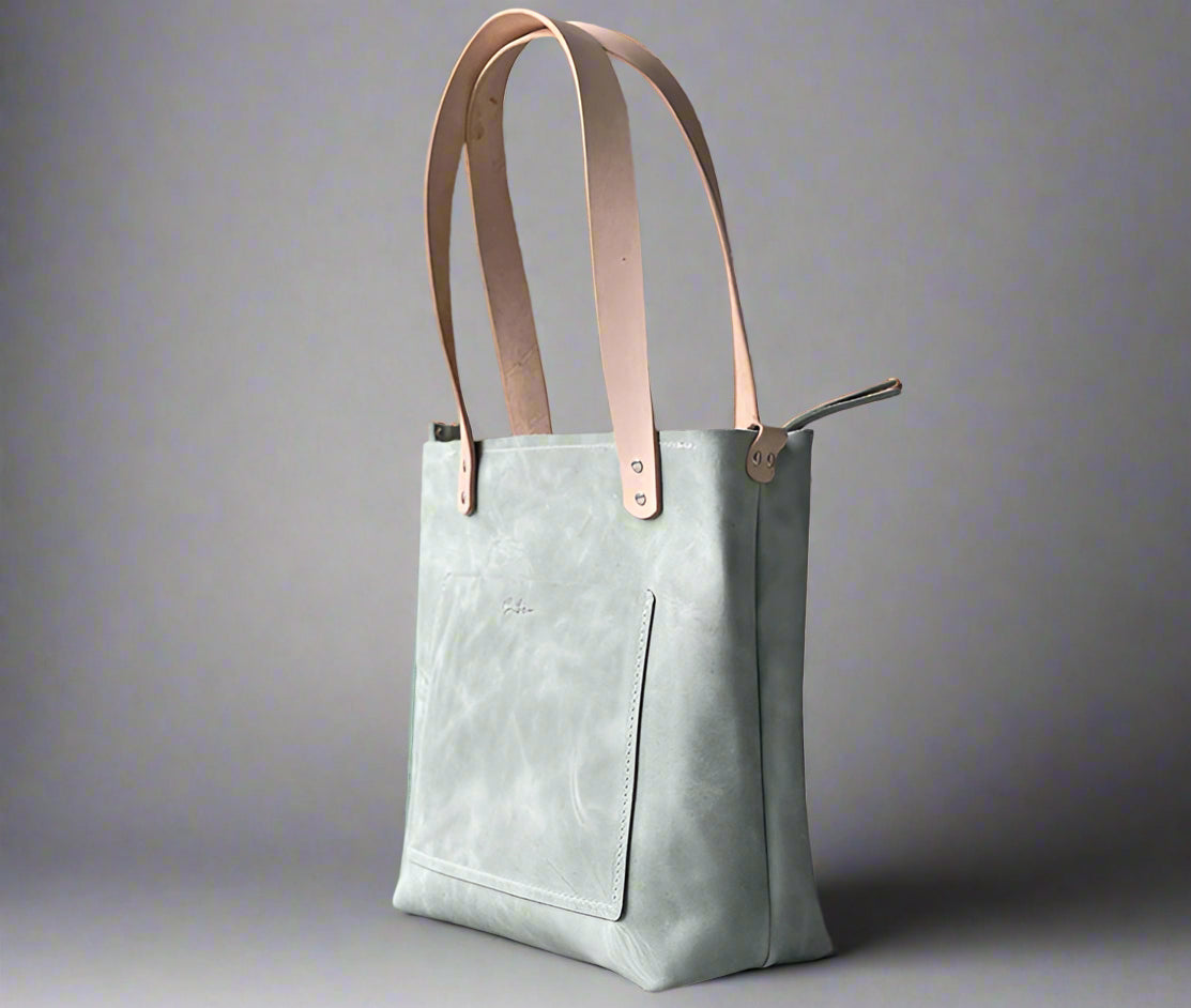 Handmade full grain leather shopper tote with structured shape and sturdy straps, crafted in Cape Town. Dusty green and natural.