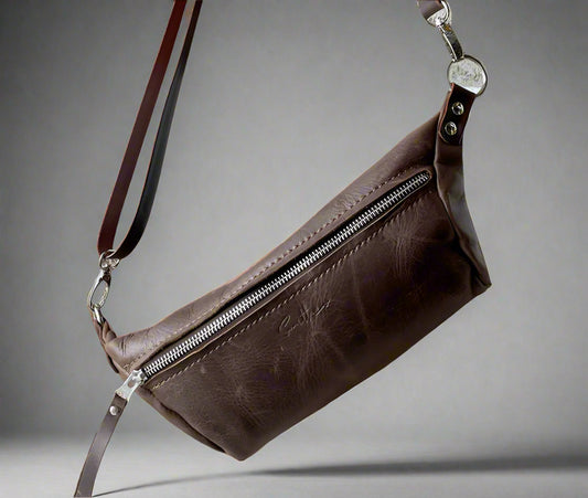 Brown full grain leather Moonsling crossbody bag with curved shape and adjustable strap, handmade in Cape Town”