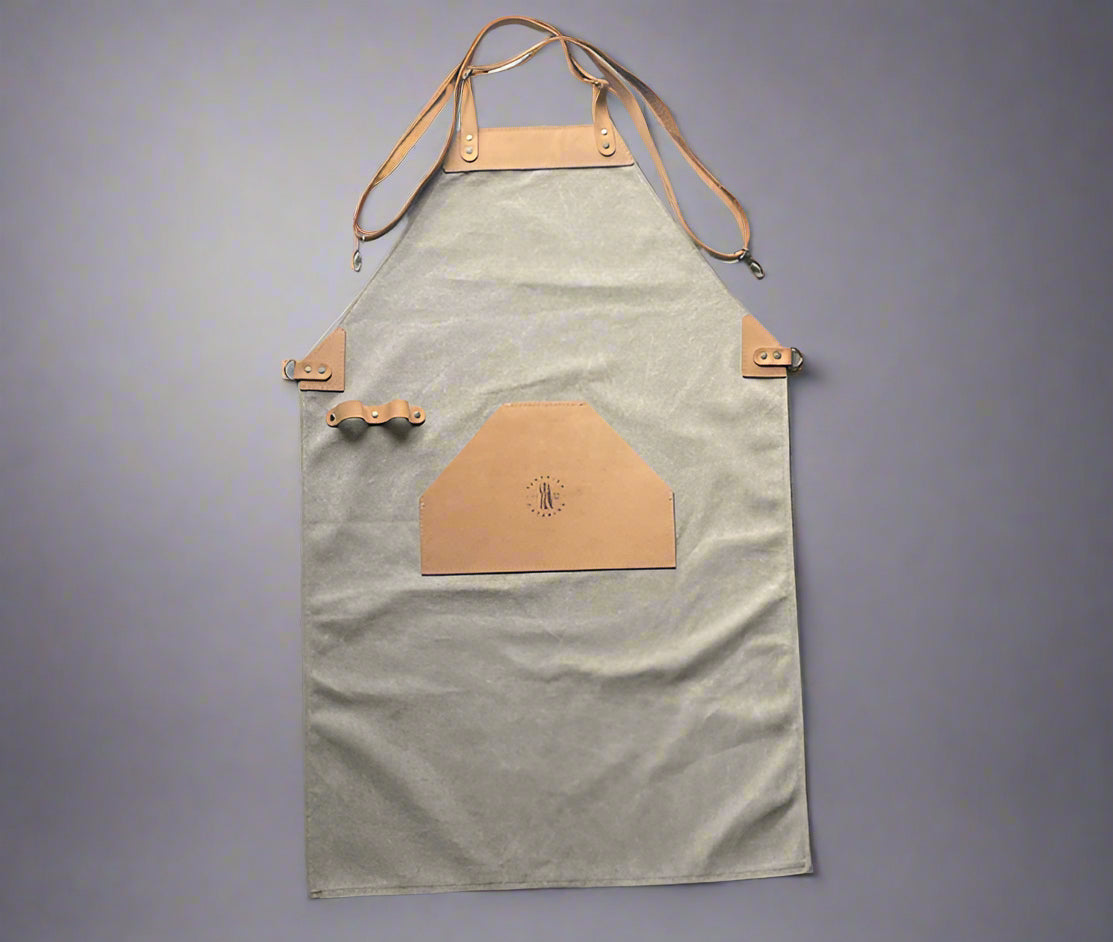 Khaki and tan canvas and leather apron with adjustable cross-back straps and utility pockets, handmade in Cape Town. Available for corporate branding.